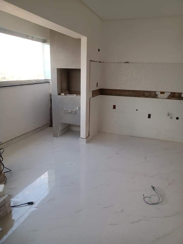 Cozinha com porcelanato branco e churrasqueira